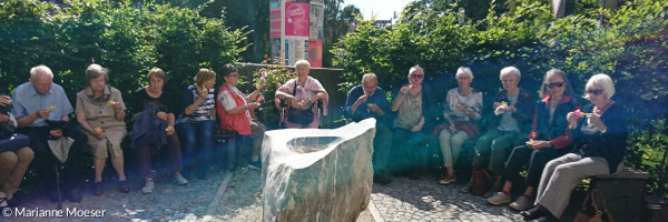 Phänologischer Garten mit Taufstein und Teilnehmer am Cafe am Montag